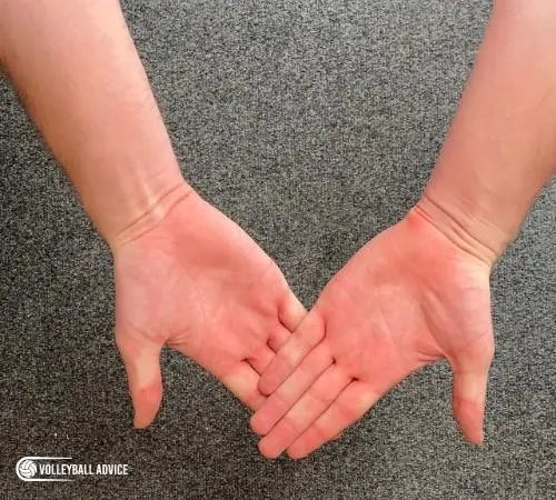 How to make proper hand position for volleyball bumps, passes, and digs Step 2: With straightened hands, stack your fingers (not palms) on top of each other.